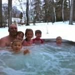 A young family enjoying the spa at the Presidents' Suites. The spas are operational year around. / une jeune famille profitant du spa extérieur en hiver aux Suites des Présidents.